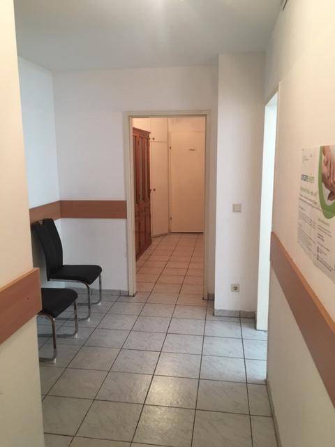 Gefliester Flur mit Sitzgelegenheiten und Zugang zu weiteren Räumen.