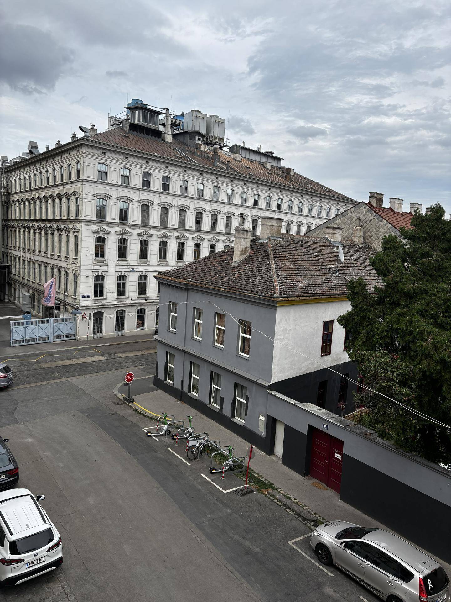 Panoramablick auf eine Straßenecke mit historischen Gebäuden und parkenden Fahrrädern.