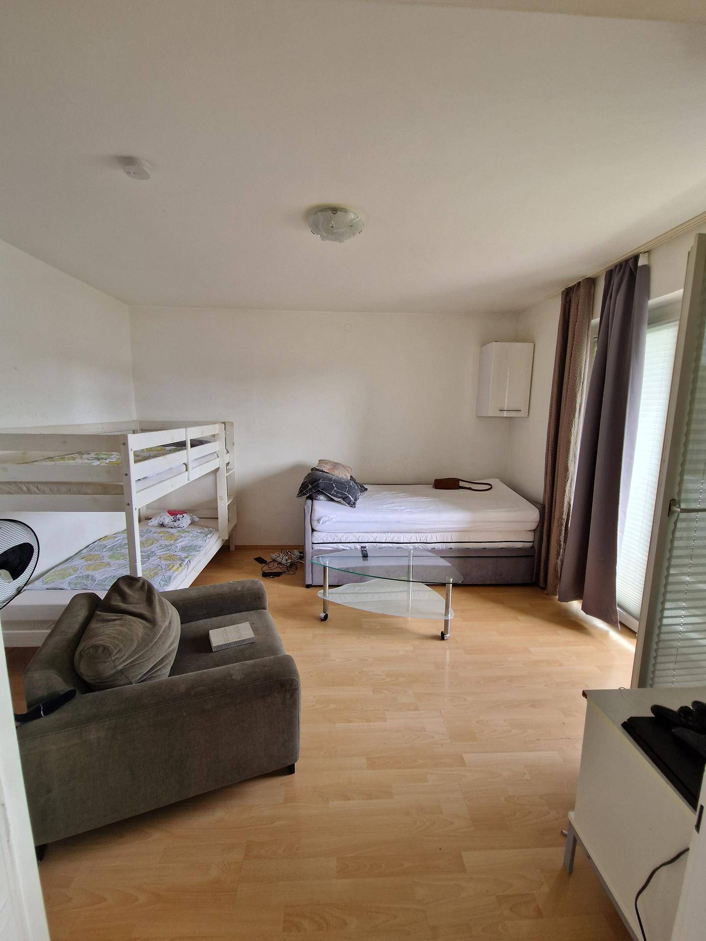 Schlafzimmer mit Etagenbett, Einzelbett und direktem Zugang zu einem Außenbereich.