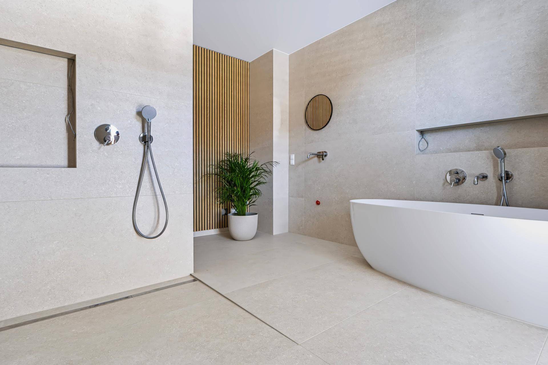 Modernes Badezimmer mit freistehender Badewanne, begehbarer Dusche und hellen Fliesen.