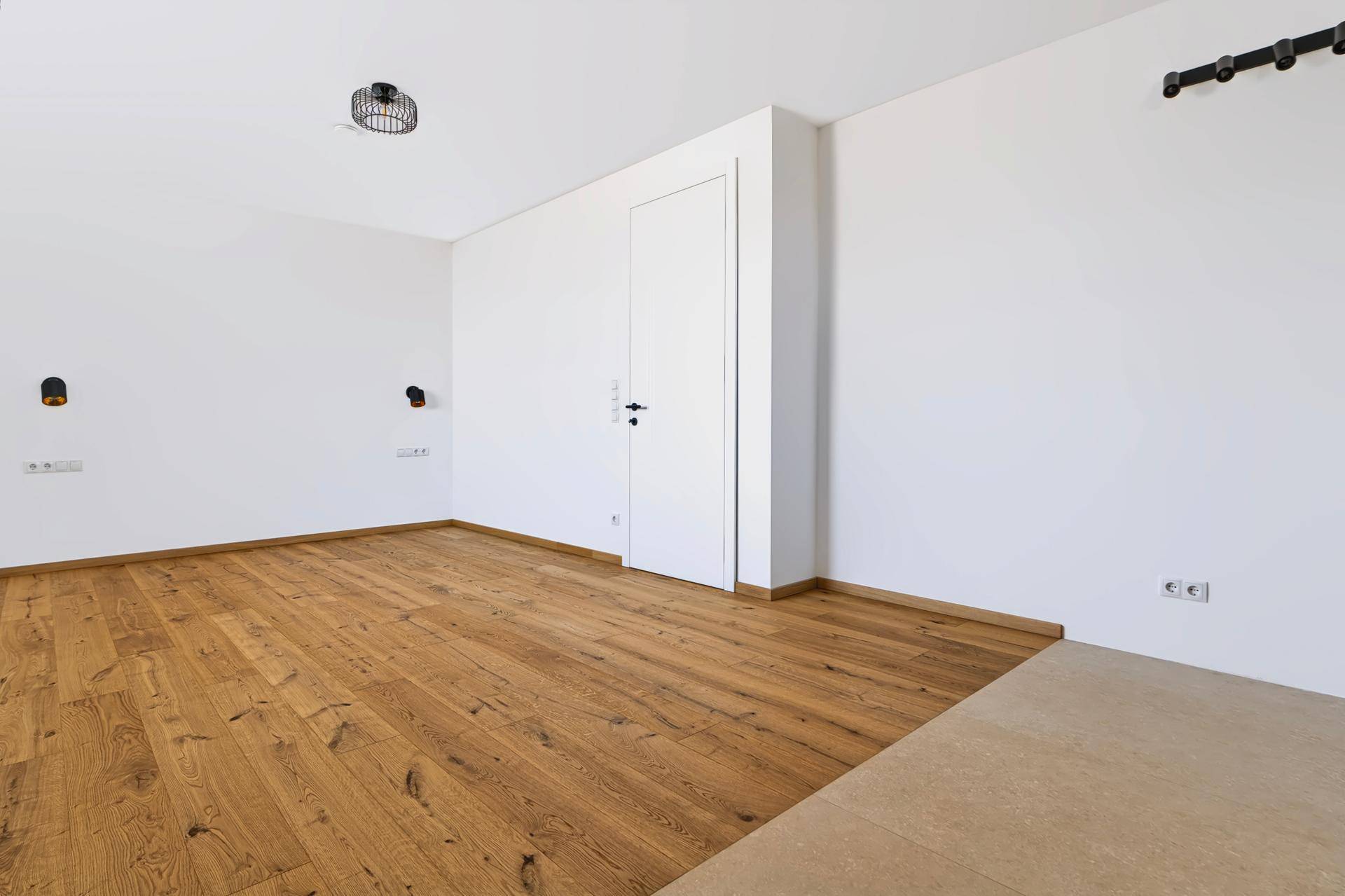 Geräumiges Schlafzimmer mit Eichenparkettboden und weiß gestrichenen Wänden, bereit zur Einrichtung.