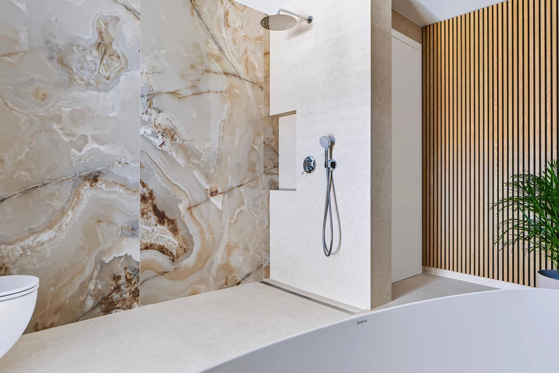 Elegante begehbare Dusche mit Regenduschkopf und luxuriösen Marmorfliesen.