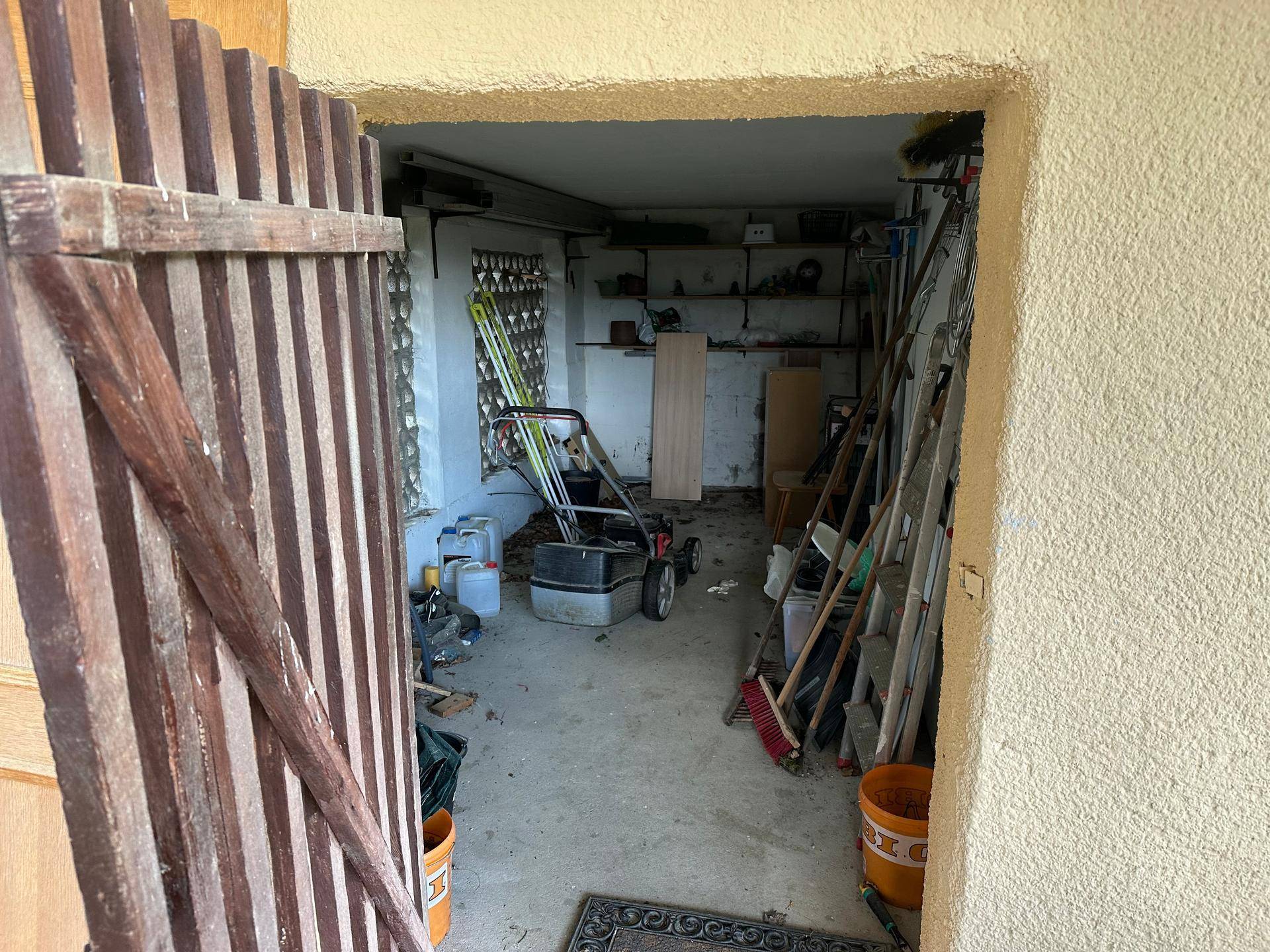 Abstellraum oder Werkstatt mit Regalen, Gartengeräten und verschiedenen Utensilien.