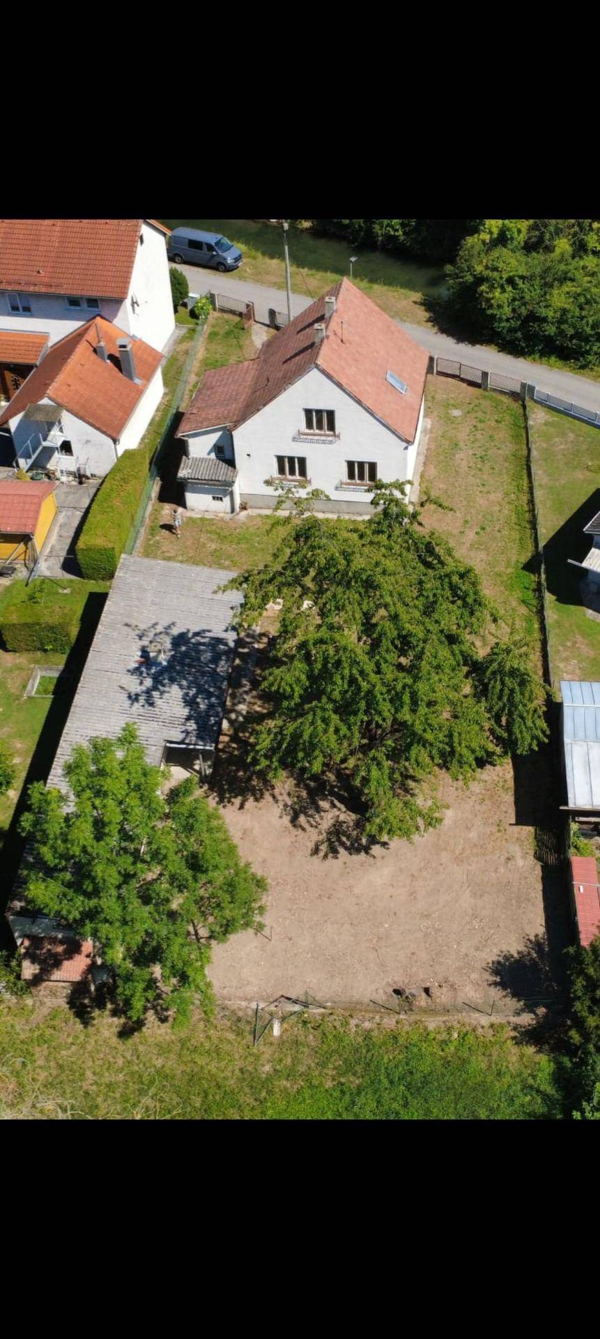 Weitläufige Luftaufnahme des Grundstücks mit Haupthaus, Nebengebäude und altem Baumbestand.