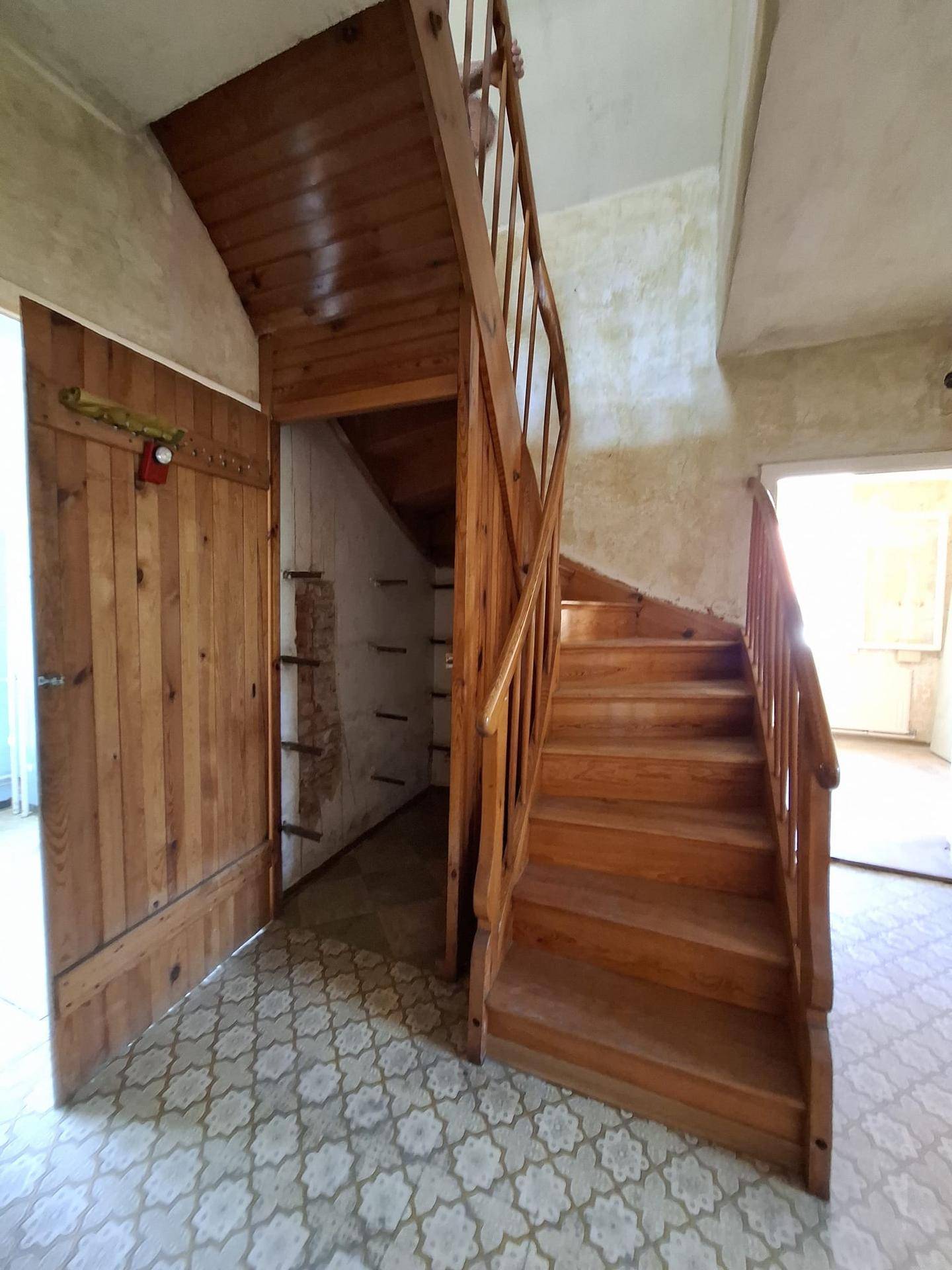 Flur mit einer Holztreppe und einem praktischen Abstellraum unter der Treppe.