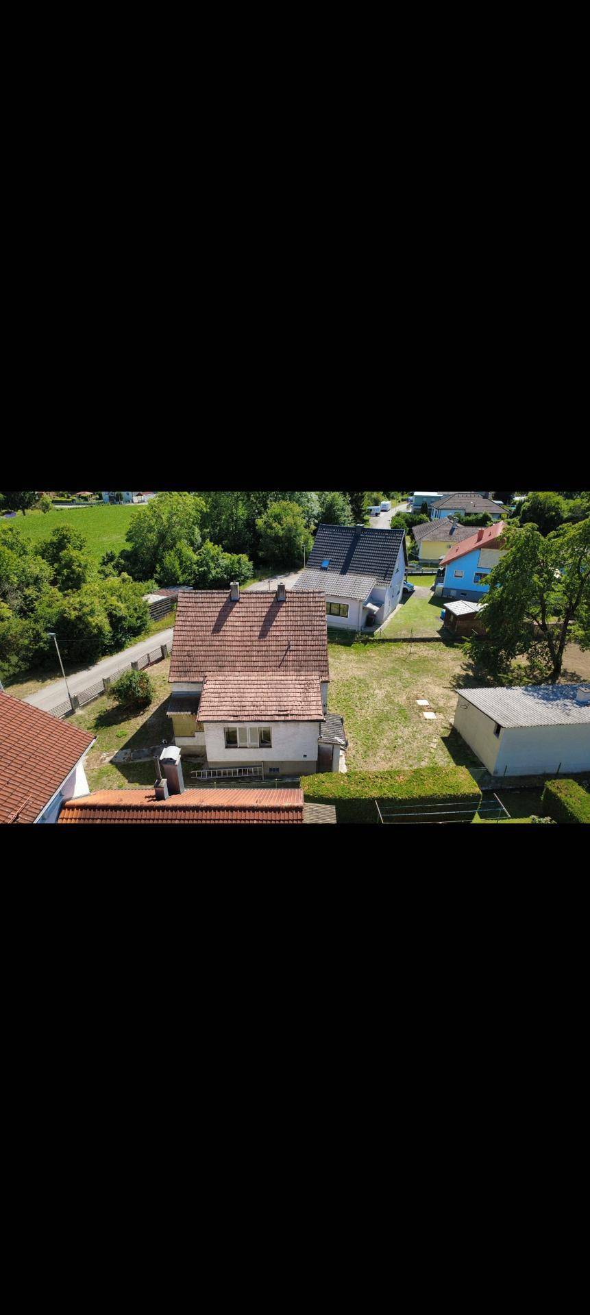 Überblick über das Anwesen von hinten, mit dem Haus, Nebengebäude und der weiteren Nachbarschaft.