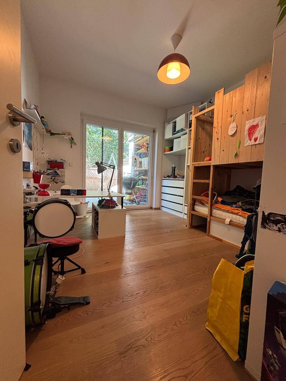 Kinderzimmer mit Hochbett, Schreibtisch und direktem Zugang zum Garten.