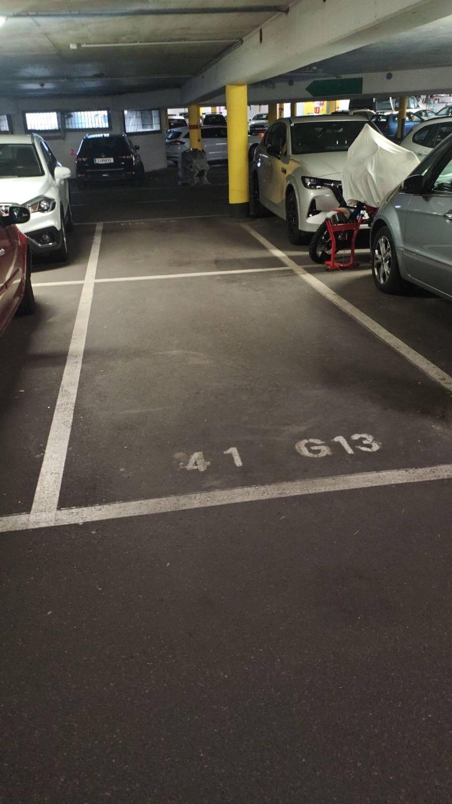 Tiefgarage mit markierten Parkplätzen und mehreren abgestellten Fahrzeugen.