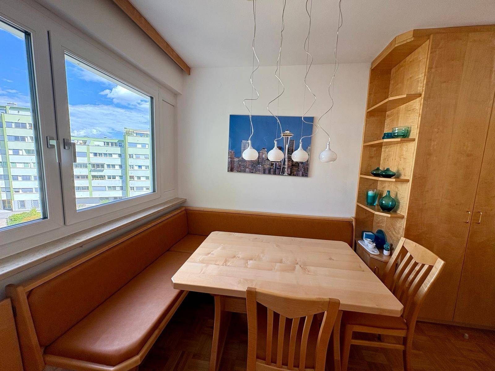 Gemütlicher Essbereich mit Holztisch, Eckbank und Blick aus dem Fenster.