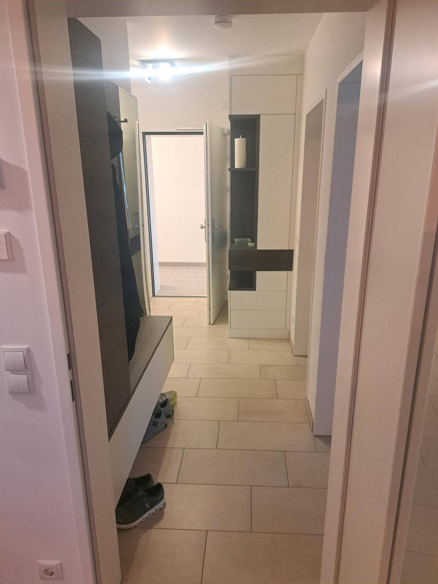 Heller Flur mit Fliesenboden, Garderobe und Zugang zu weiteren Räumen der Wohnung.