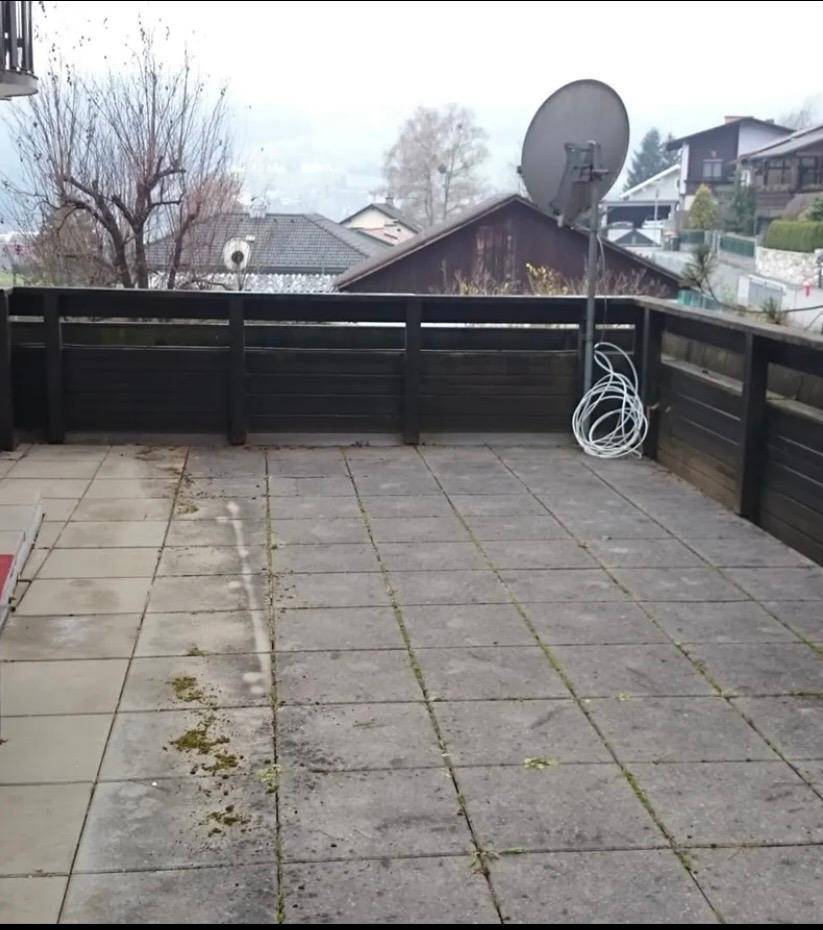 Geräumige geflieste Terrasse mit Satellitenschüssel und Blick auf die umliegende Wohngegend.