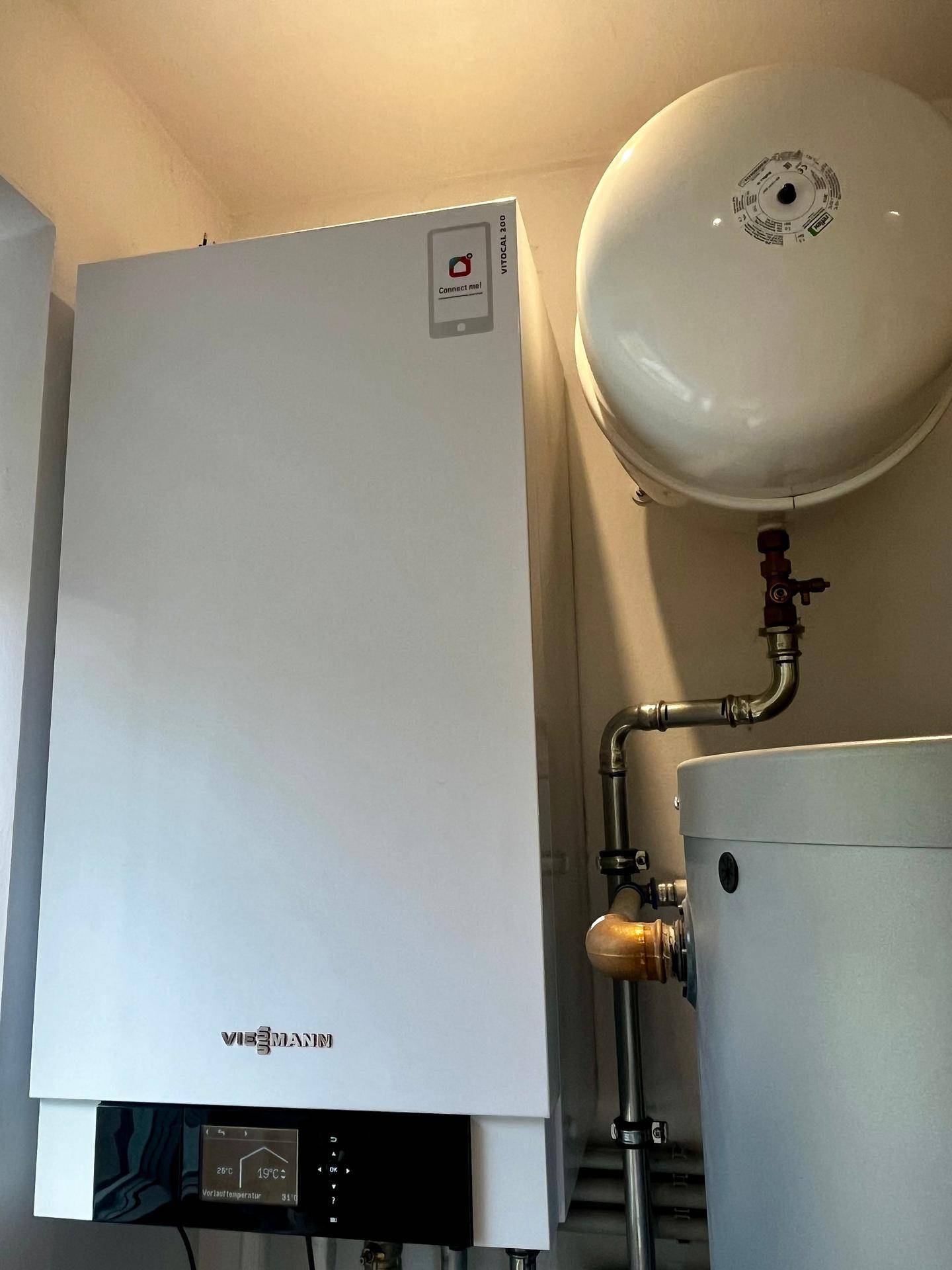 Moderne Heizungsanlage von Viessmann mit Warmwasserspeicher in einem Technikraum.