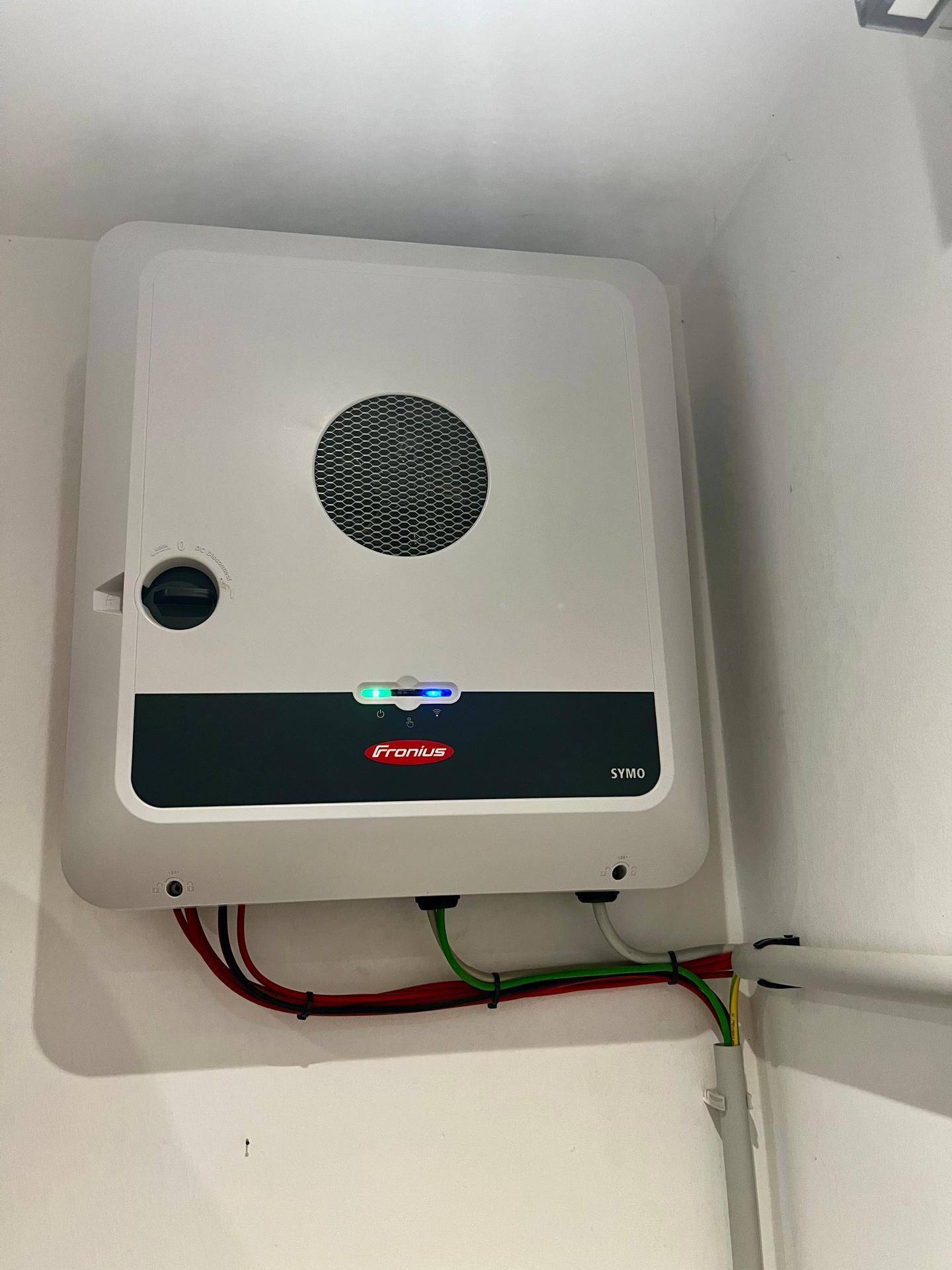 Ein moderner Wechselrichter des Photovoltaiksystems ist ordentlich an der Wand montiert und zeigt den Betriebsstatus an.