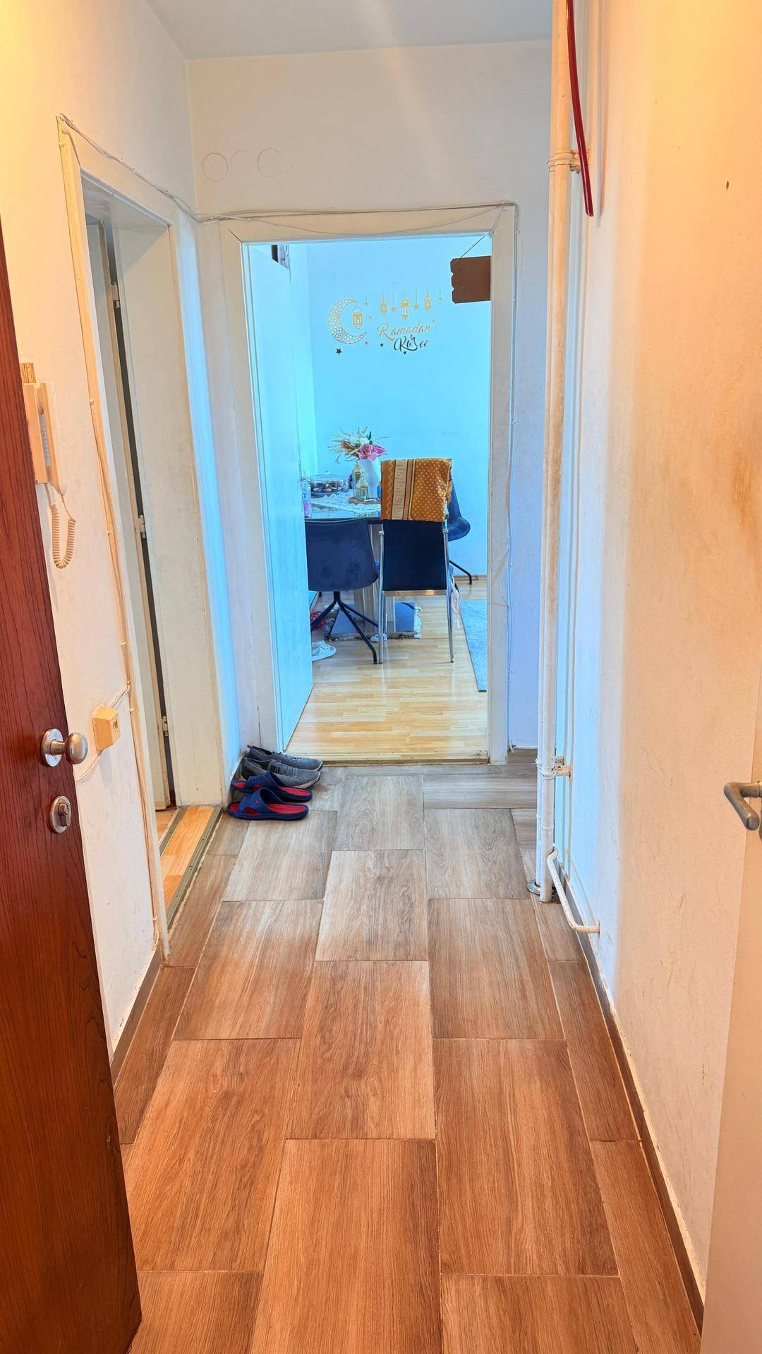Heller Flur mit Holzoptik-Fliesenboden, der zu den angrenzenden Räumen führt.