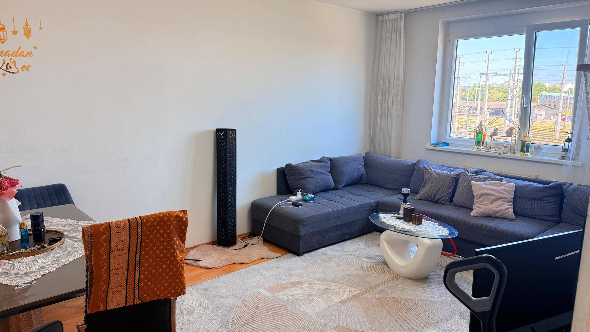 Geräumiger Wohn-Essbereich mit großem Ecksofa, Esstisch und hellem Fenster.