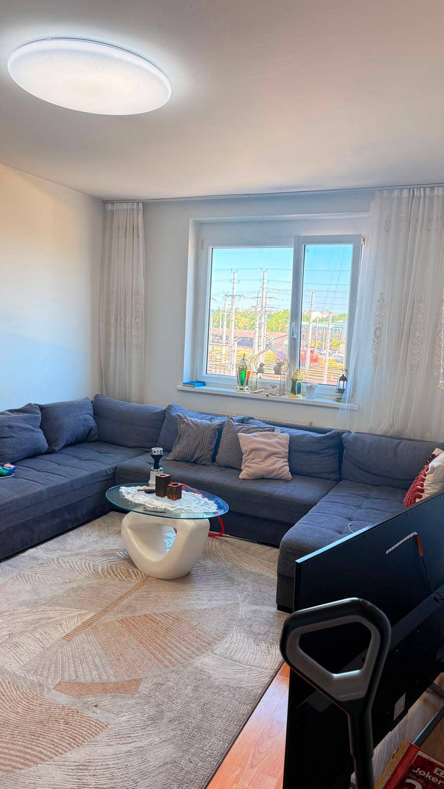 Heller Wohnbereich mit bequemem Ecksofa, modernem Couchtisch und großem Fenster.