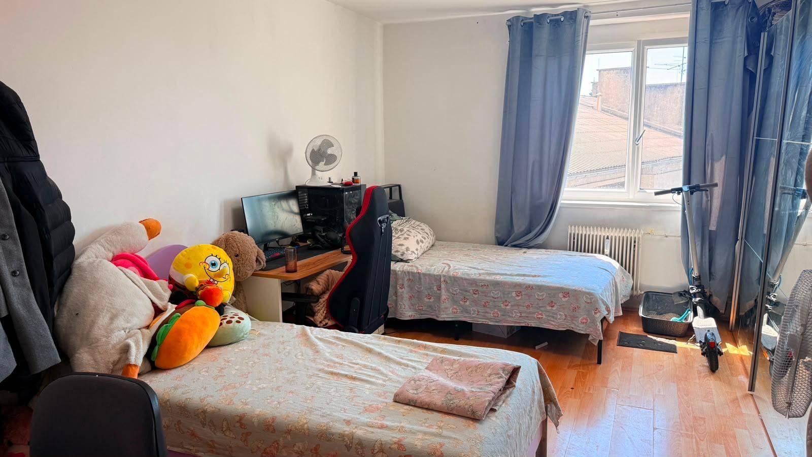Kinder- oder Gästezimmer mit zwei Einzelbetten, Schreibtisch und Fenster.
