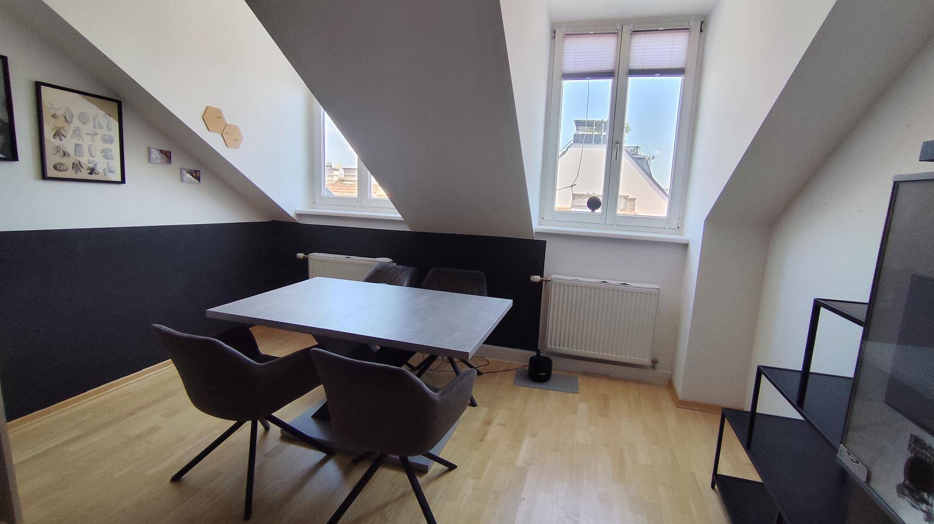 Lichtdurchfluteter Essbereich mit großen Fenstern, Heizkörpern und einem modernen Esstisch für gesellige Runden.