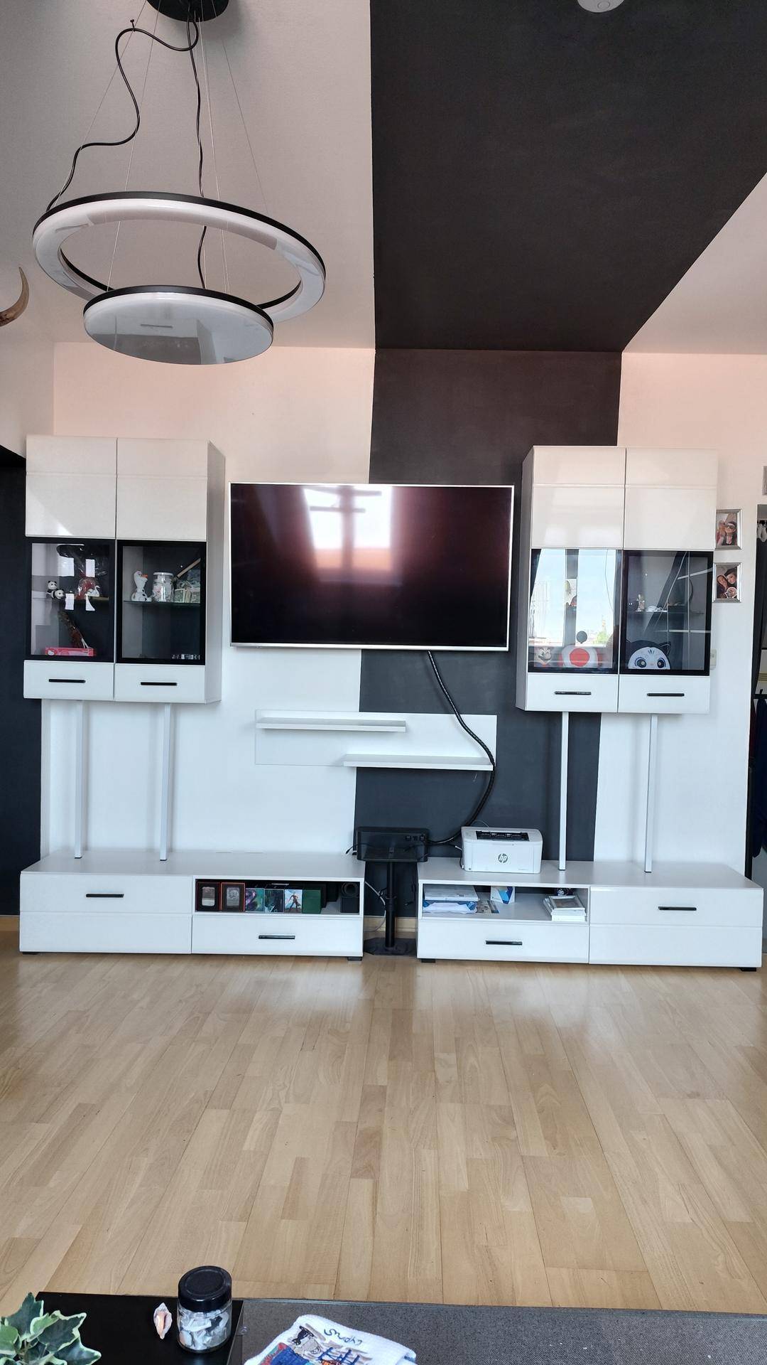 Detailansicht der modernen Medieneinheit und einer stilvollen Deckenleuchte im Wohnzimmer.