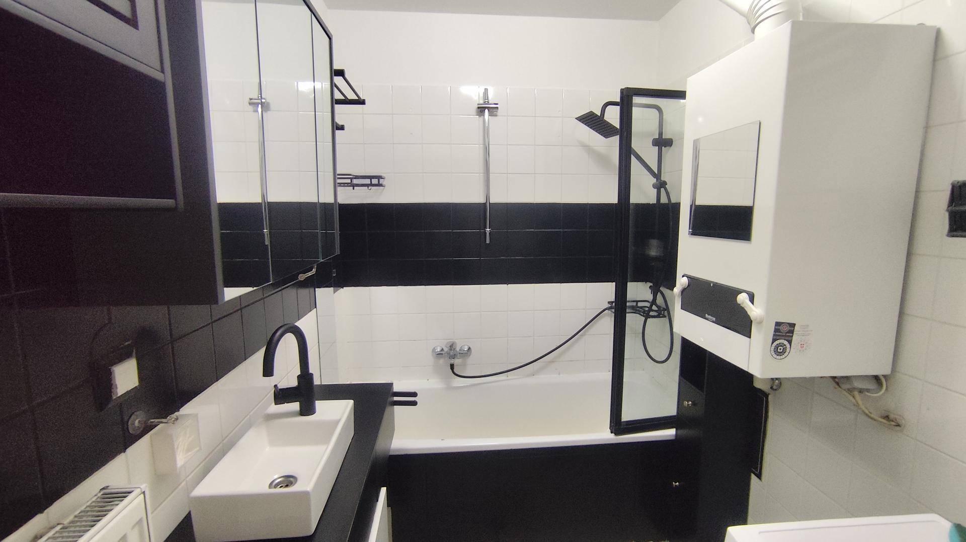 Stilvolles Badezimmer mit modernem Waschbecken, Spiegelschrank und Badewanne.