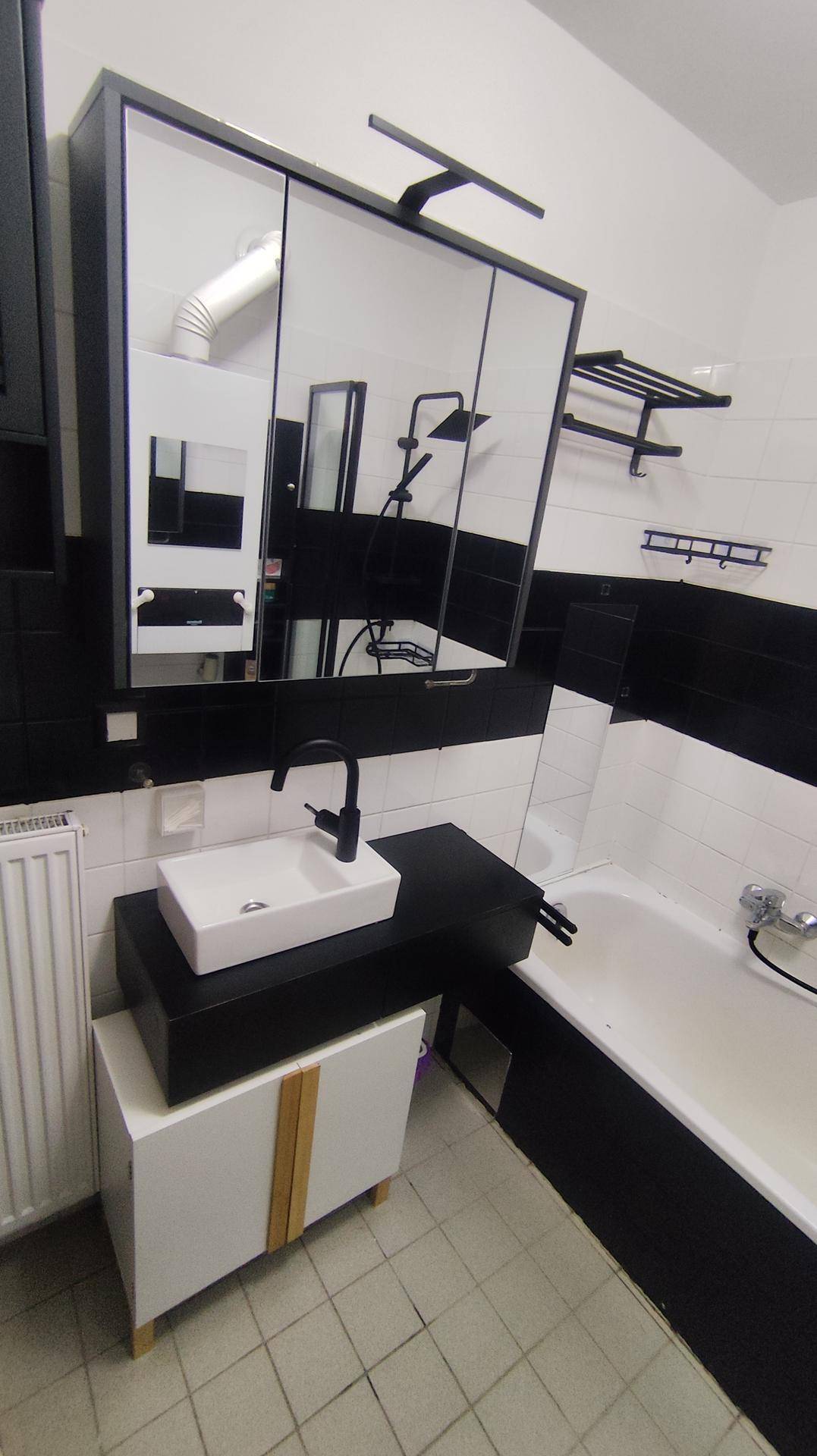 Modernes Badezimmer mit Aufsatzwaschbecken, Spiegelschrank und Badewanne.