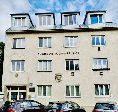 Fassade des Theodor Iglseder-Hofs mit mehreren Stockwerken und Mansarddach.