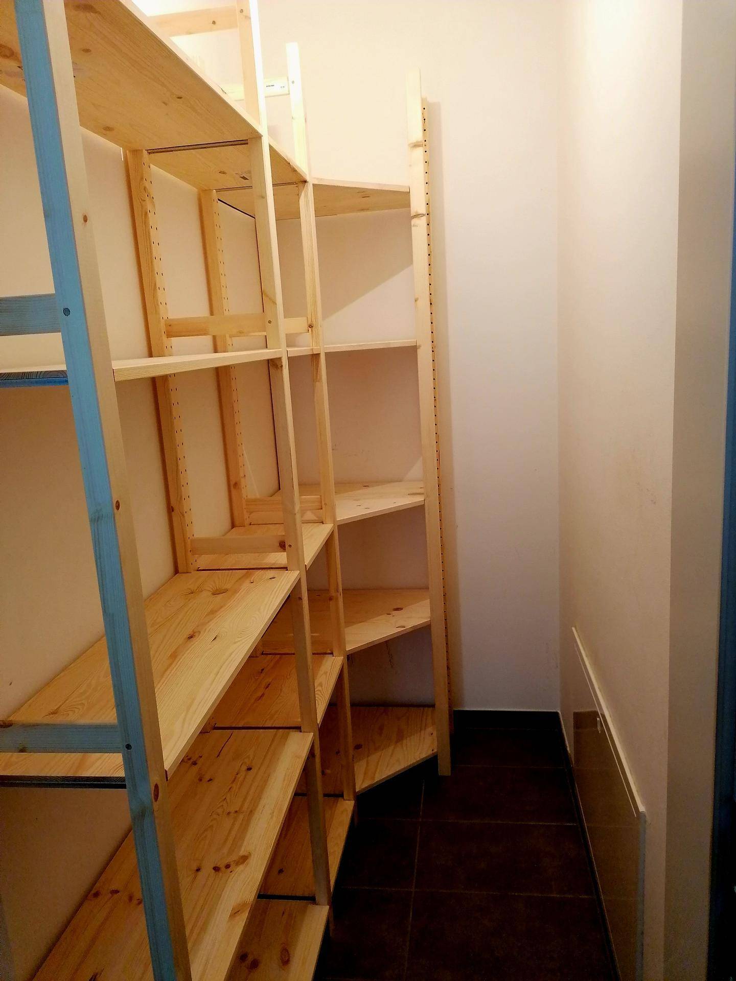 Praktischer Abstellraum mit Holzregalen, bietet viel Stauraum für Haushaltsgegenstände.