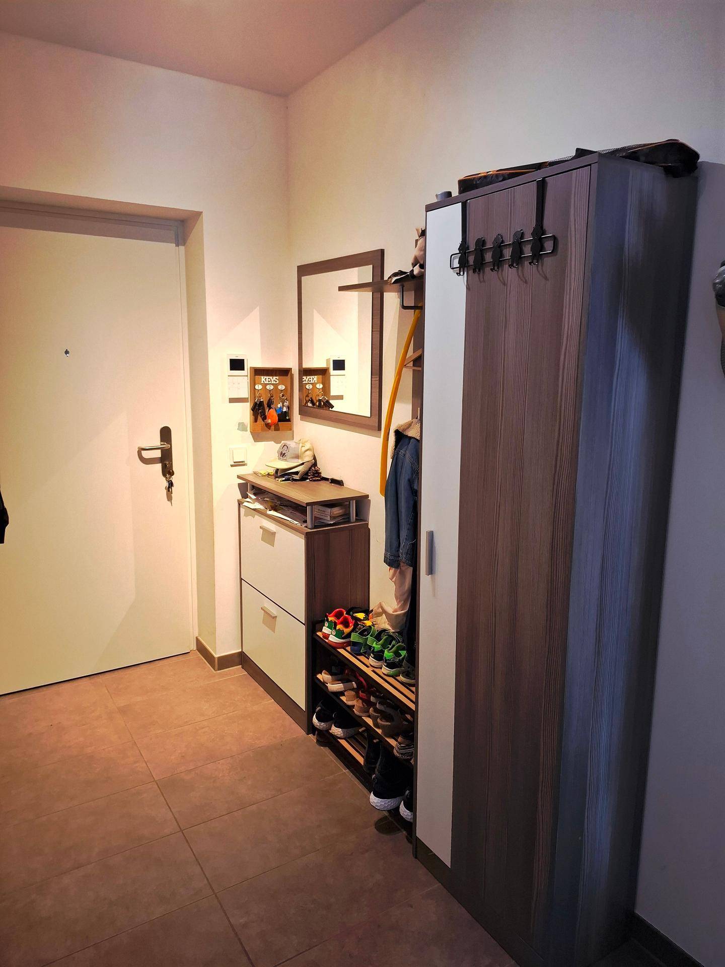 Eingangsbereich mit Fliesenboden, Schuhschrank und Garderobe, praktisch und funktional.