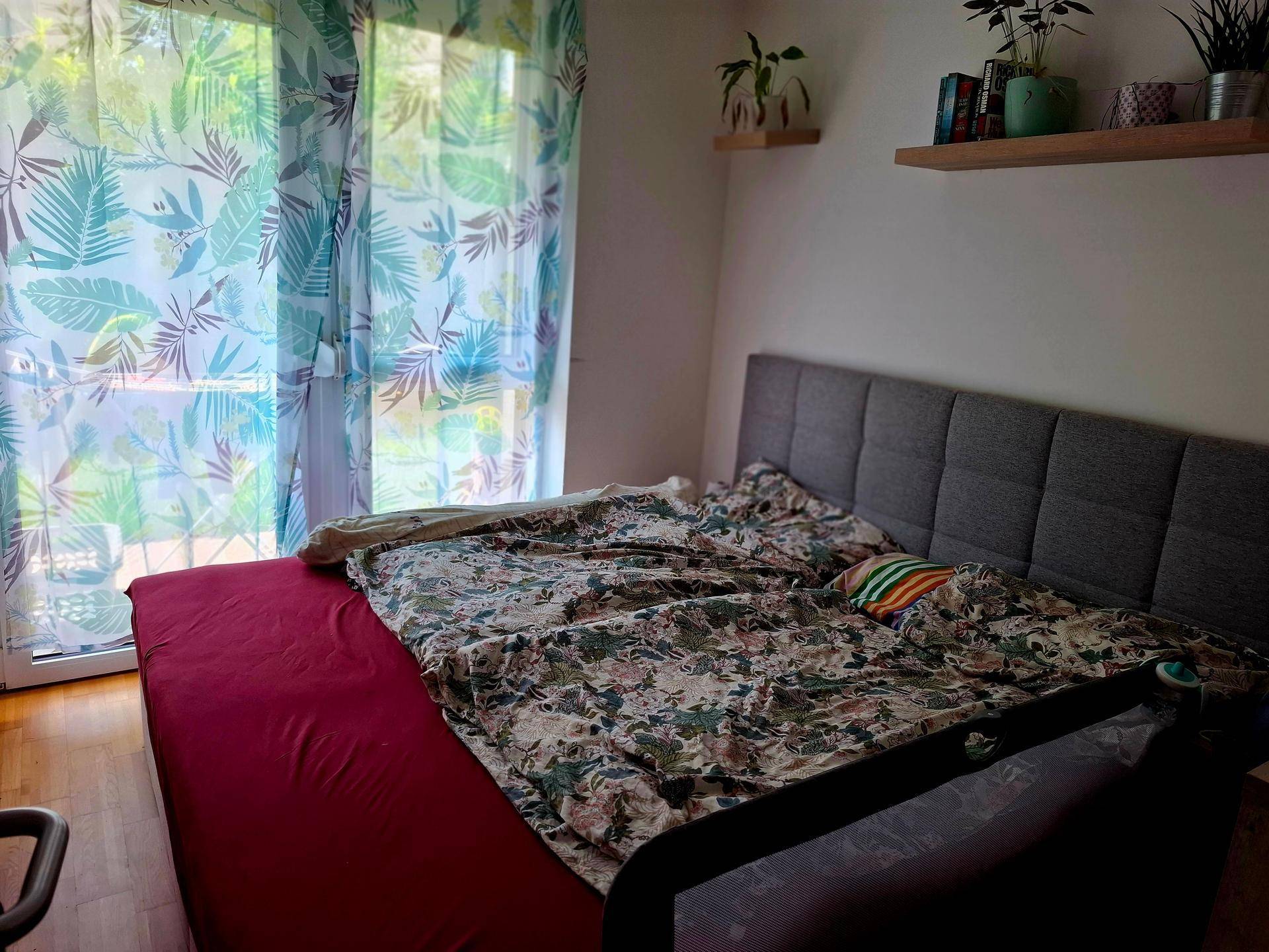 Schlafzimmer mit Doppelbett, Holzboden und Zugang zu einem Balkon oder Terrasse.