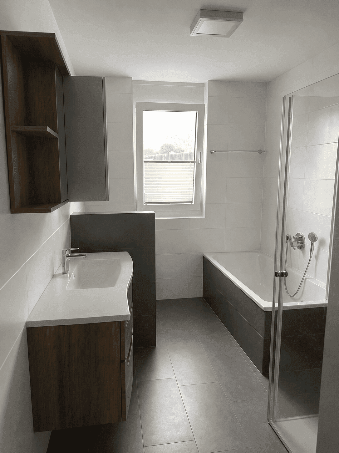 Modernes Badezimmer mit Badewanne, Duschkabine und Fenster.