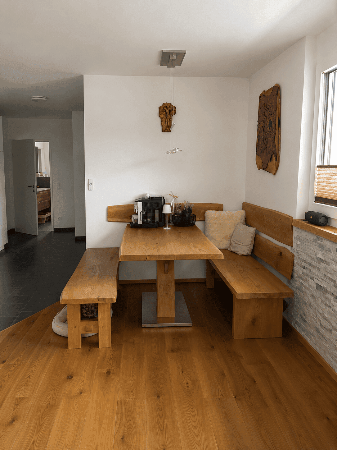 Gemütlicher Essbereich mit Holzbänken, Esstisch und Fenster.
