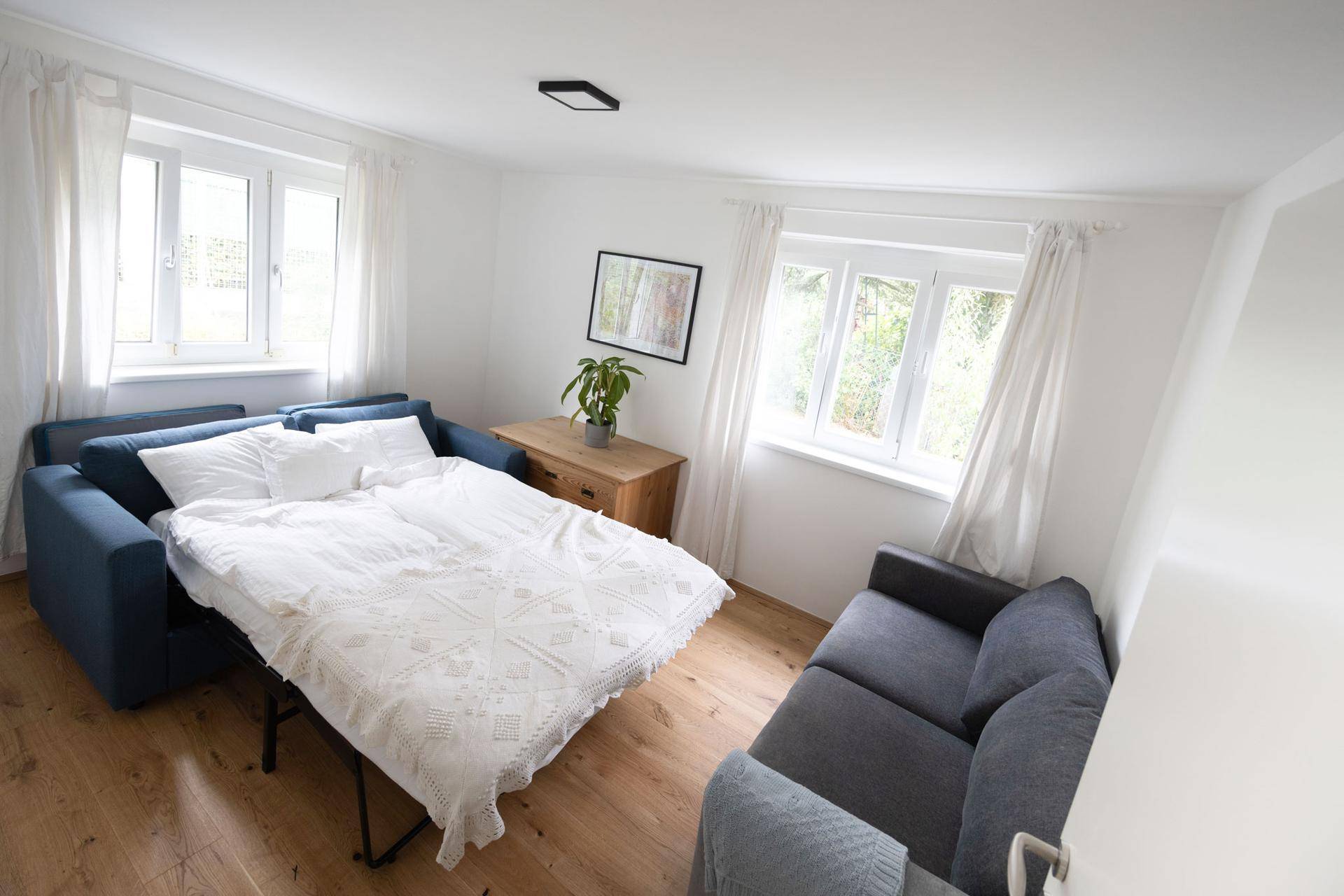 Wohnzimmer mit ausgezogenem Schlafsofa, das zusätzlichen Schlafplatz bietet.