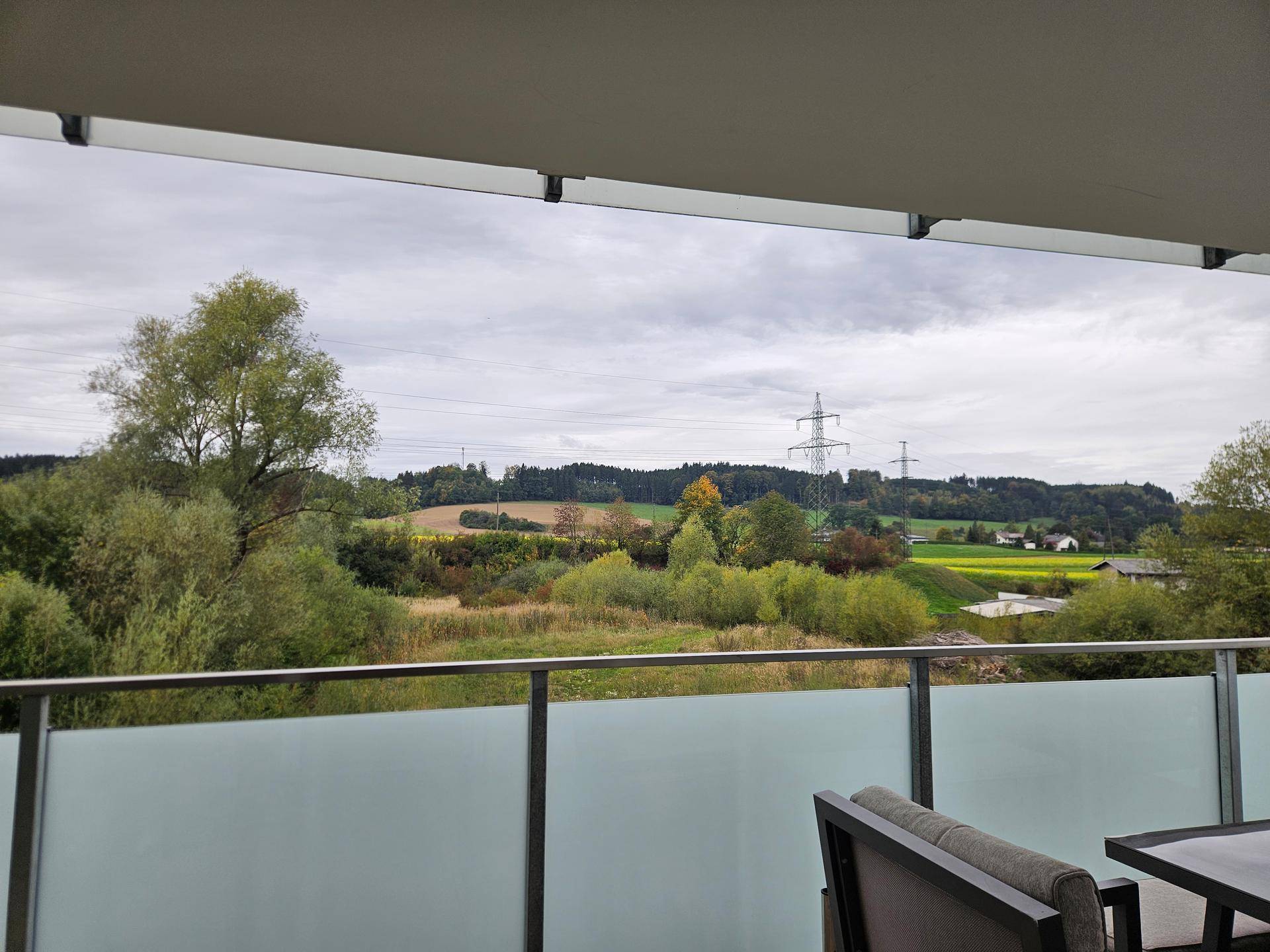 Weitläufiger Ausblick vom Balkon auf grüne Hügel und Landschaft.