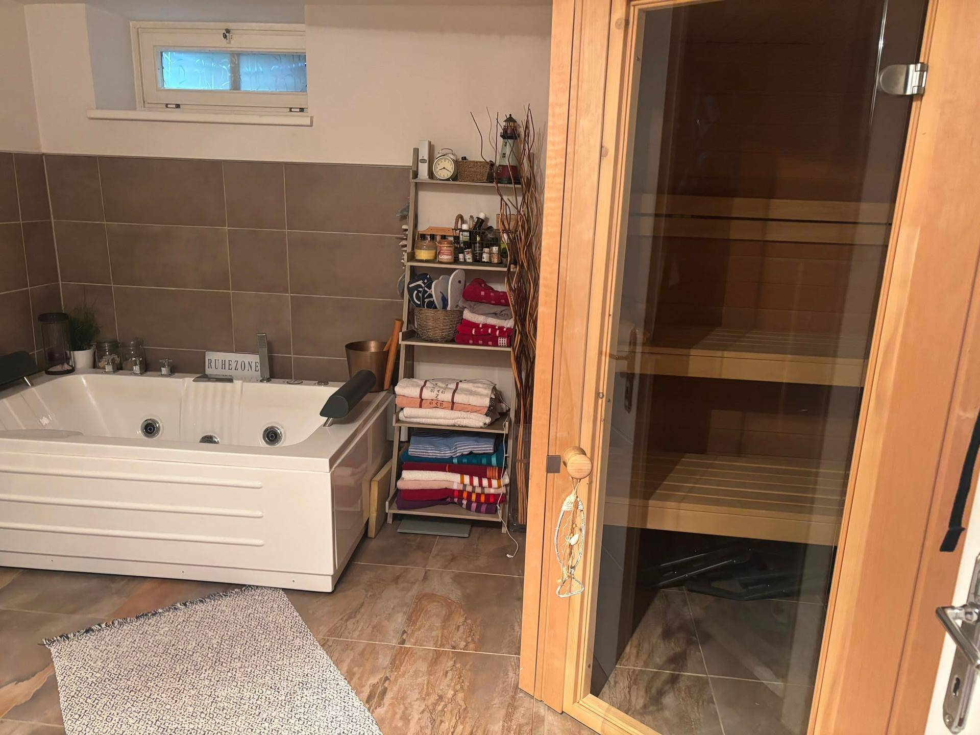 Wellnessbereich im Untergeschoss mit Whirlpool und einer privaten Sauna für Entspannung.