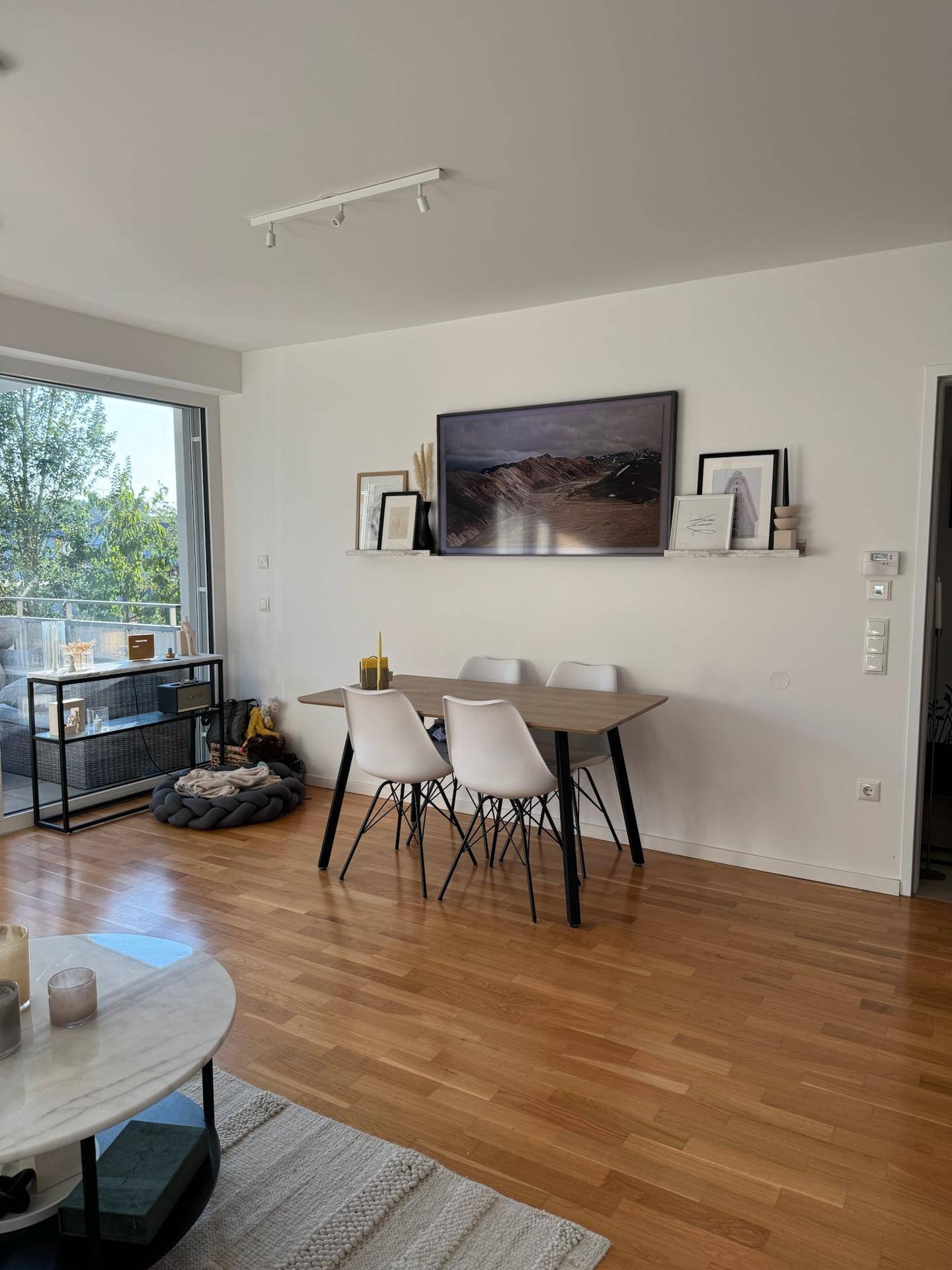 Offener Essbereich mit Holztisch und modernen Stühlen, angrenzend an den Wohnbereich.