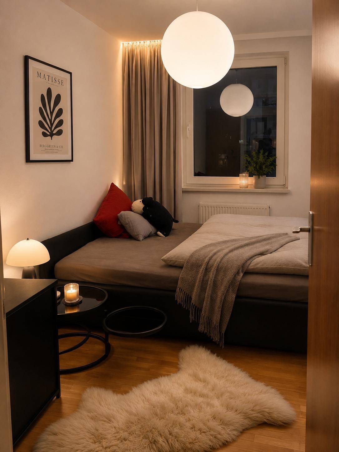 Schlafzimmer mit Einzelbett, Holzboden und flauschigem Teppich, gemütlich beleuchtet.