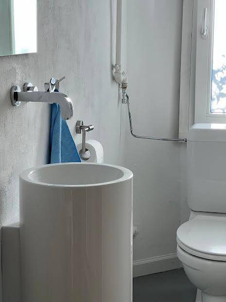 Separates WC mit modernem Standwaschbecken und Fenster für natürliche Belüftung.