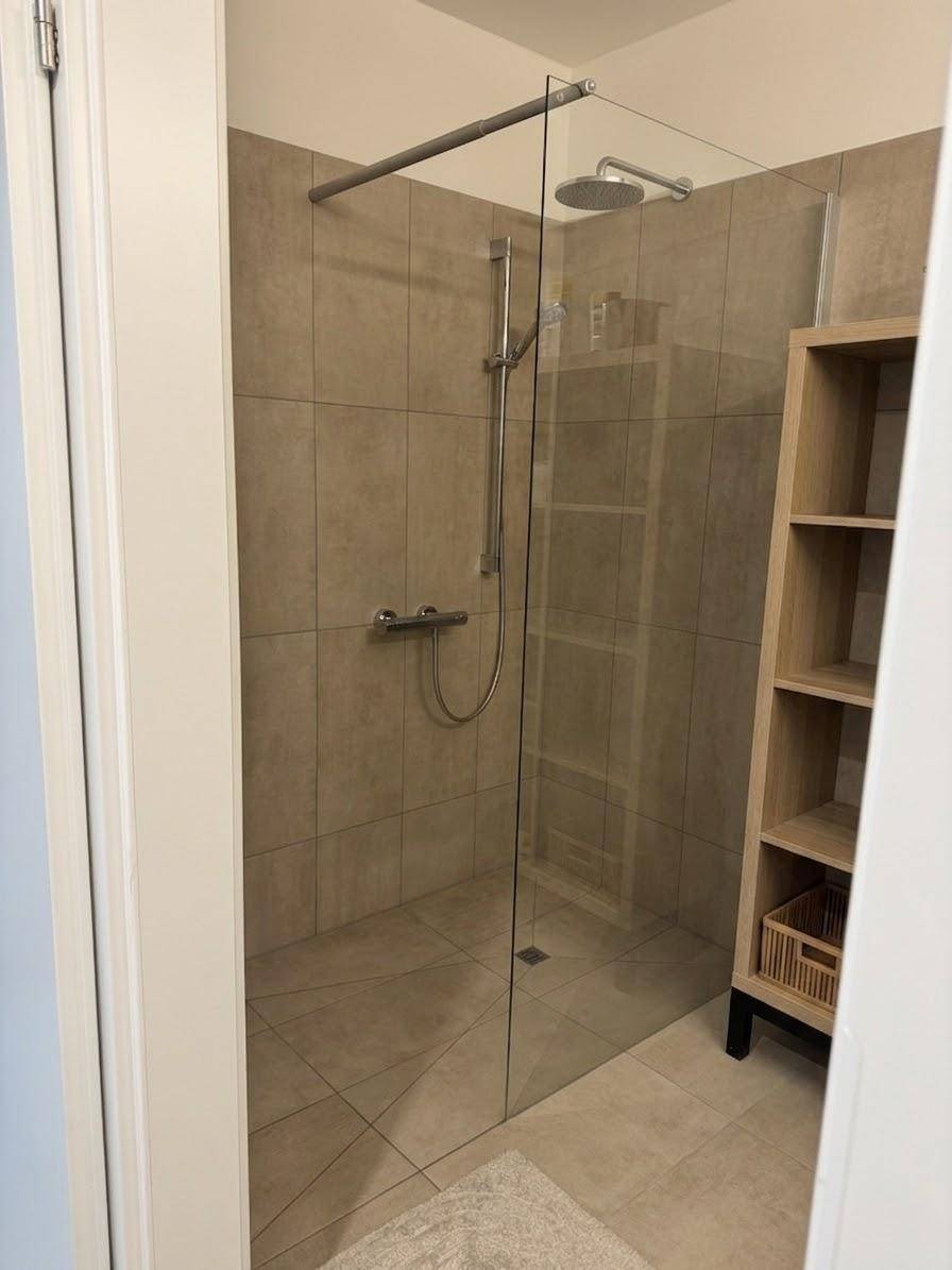 Geräumige begehbare Dusche mit Glasabtrennung und Regenduschkopf im modernen Bad.