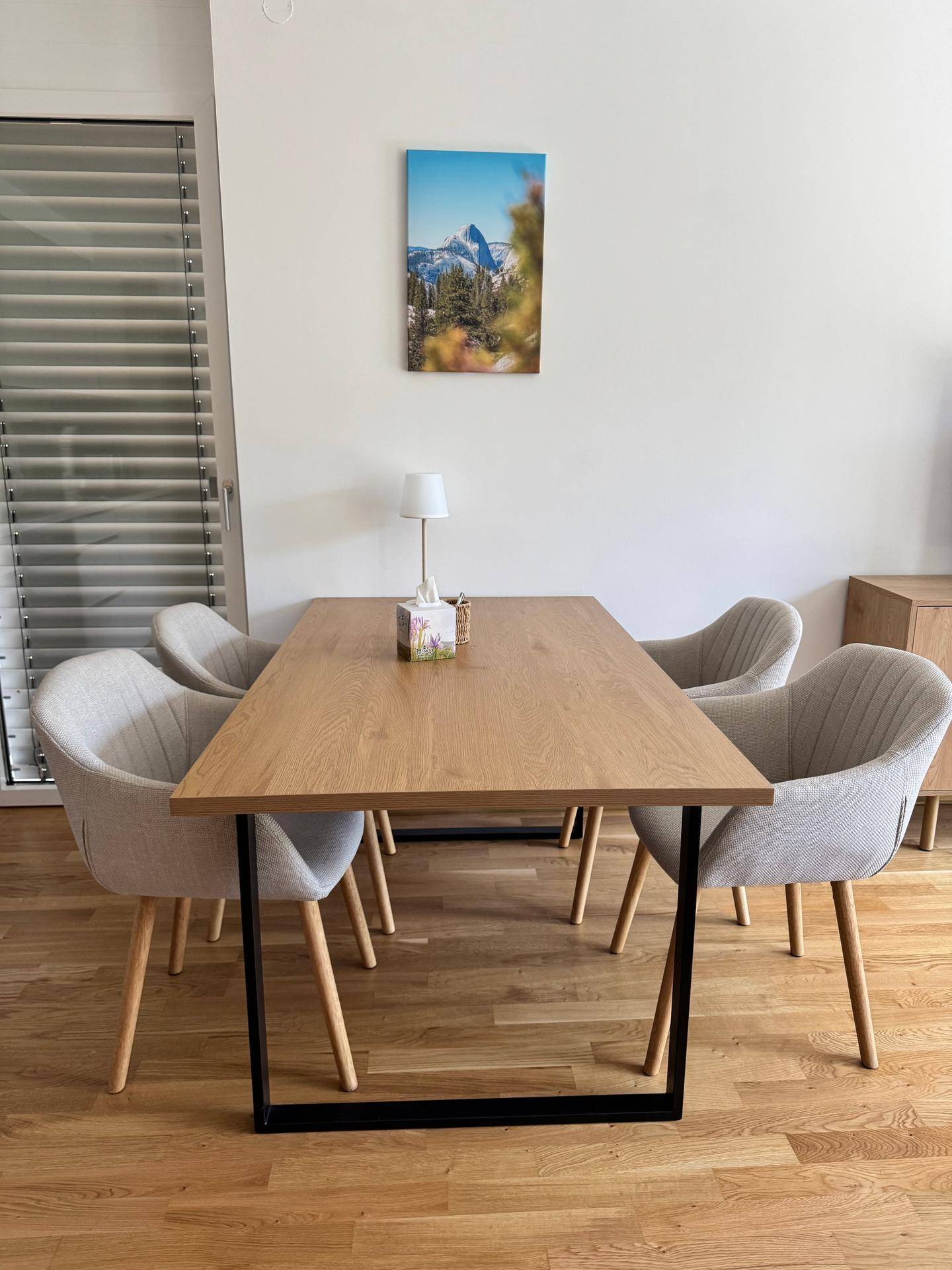 Heller Essbereich mit elegantem Holztisch und vier modernen, gepolsterten Stühlen.