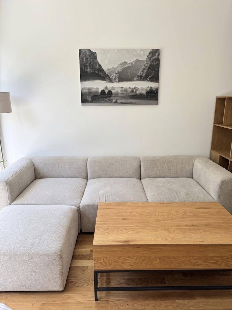 Detailansicht des Wohnbereichs mit bequemem Sofa und modernem Couchtisch aus Holz.