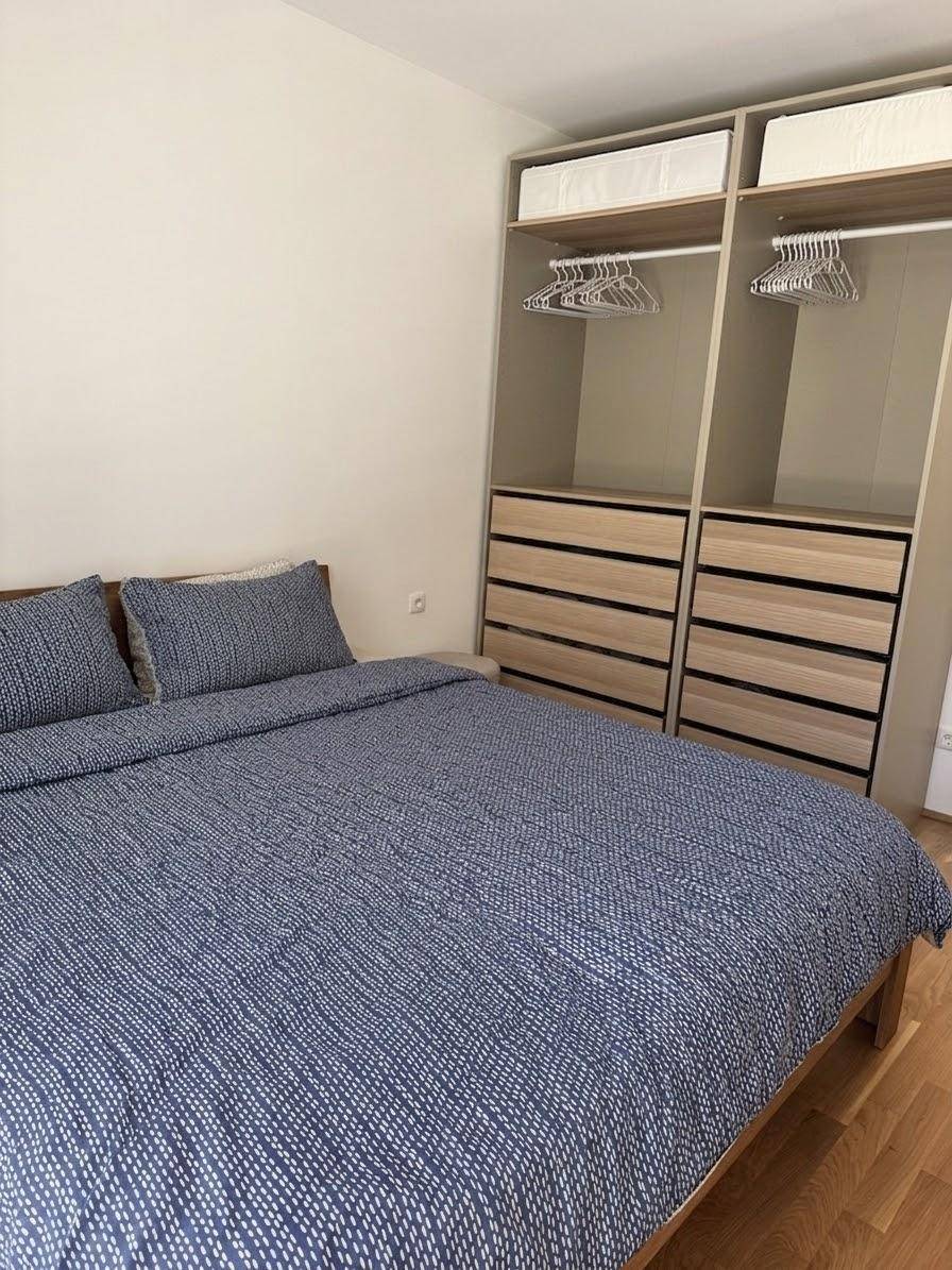 Schlafzimmer mit komfortablem Holzbett und praktischem Einbauschrank für Kleidung.