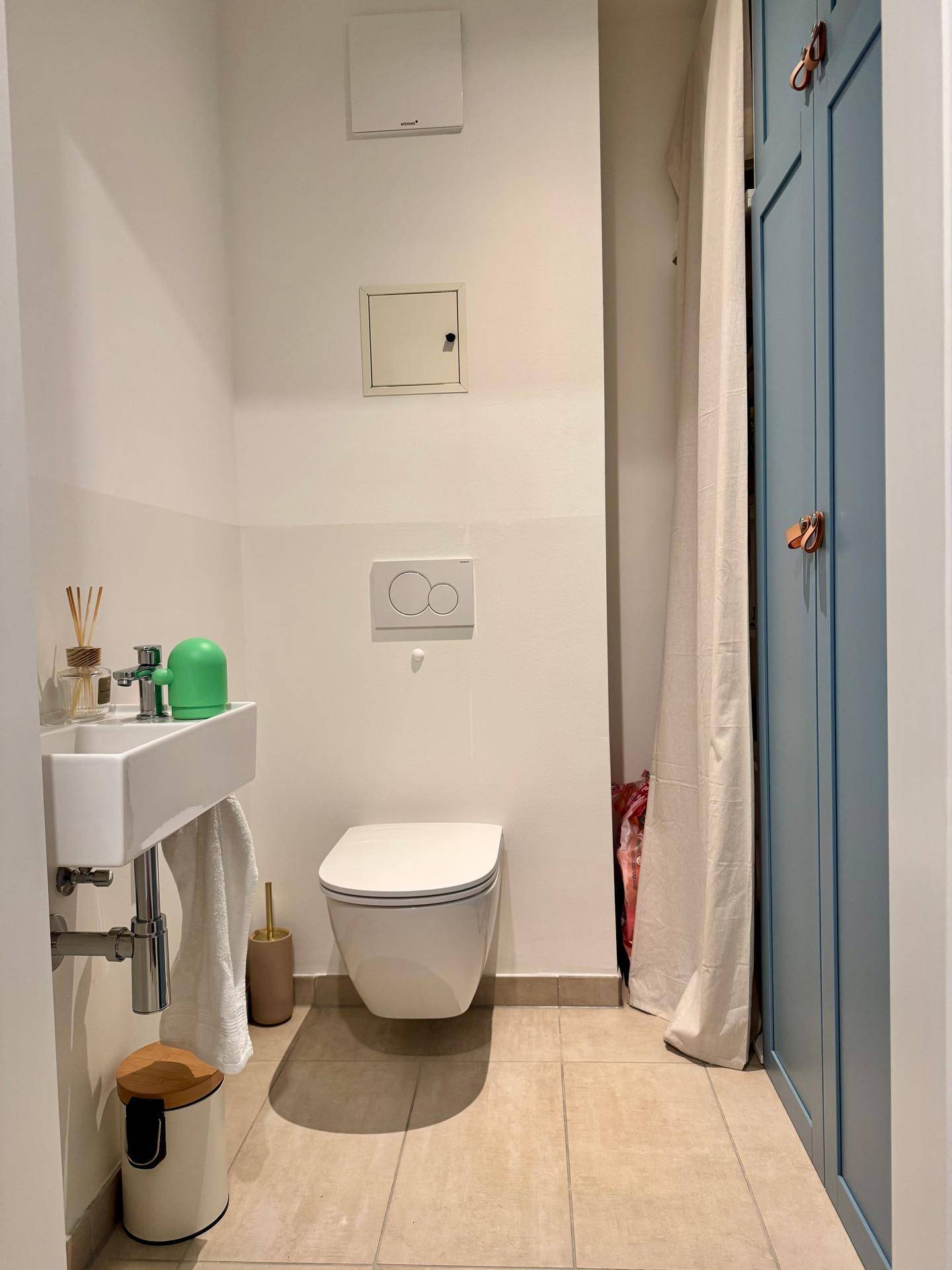 Modernes Gäste-WC mit wandhängender Toilette und kleinem Waschbecken.