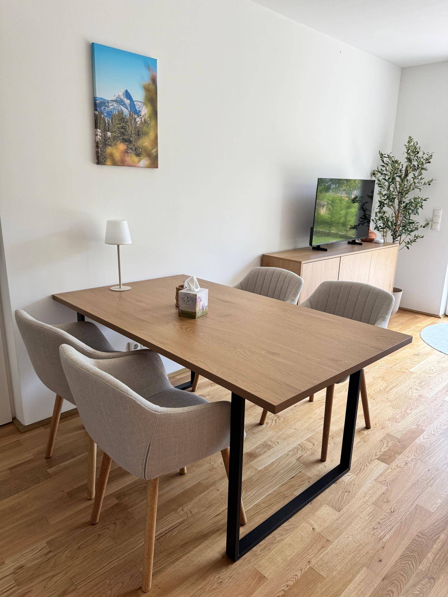 Essbereich mit modernem Holztisch, bequemen Stühlen und einem Sideboard.