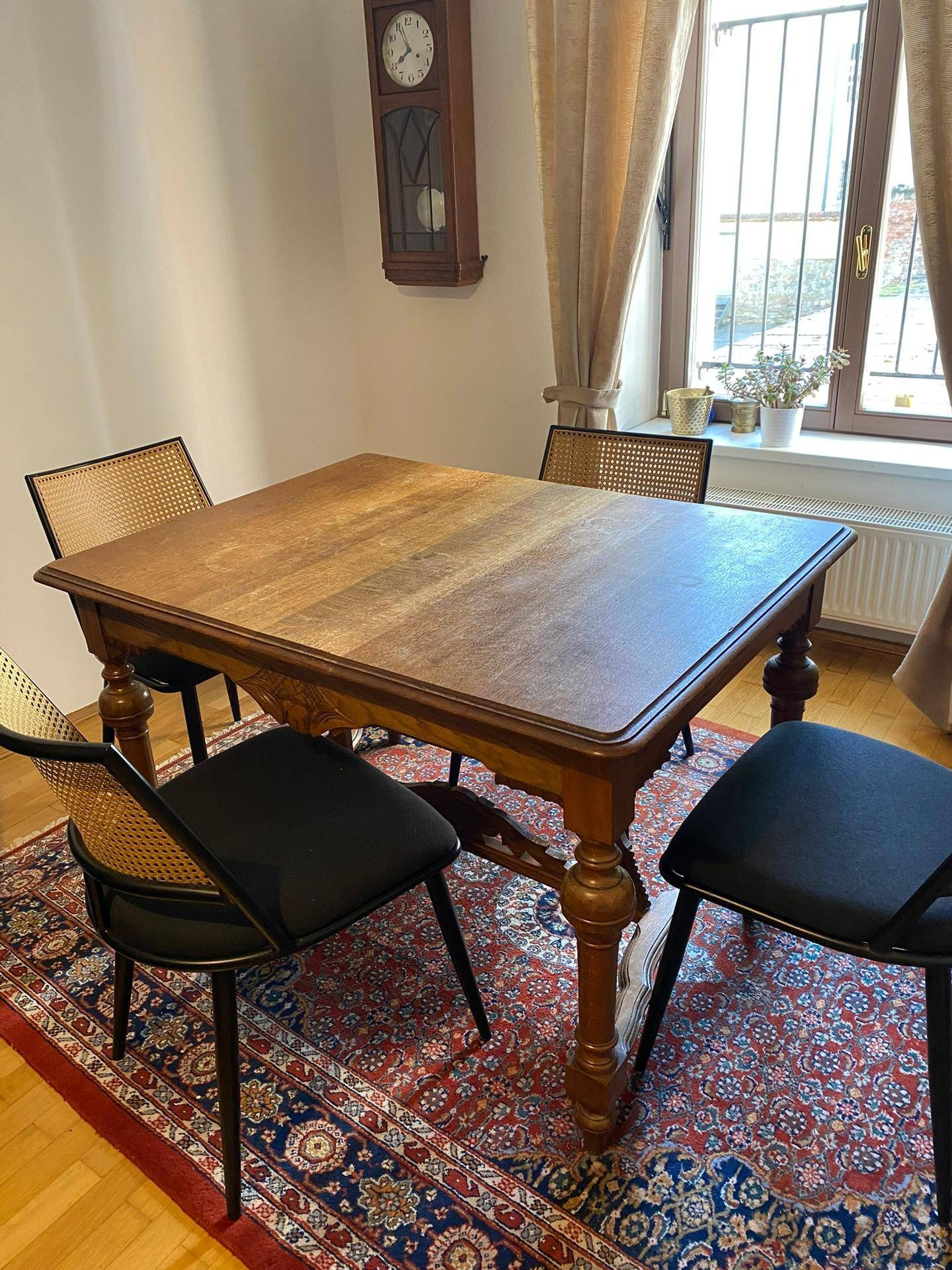 Heller Essbereich mit rustikalem Holztisch, Stühlen und Teppich.
