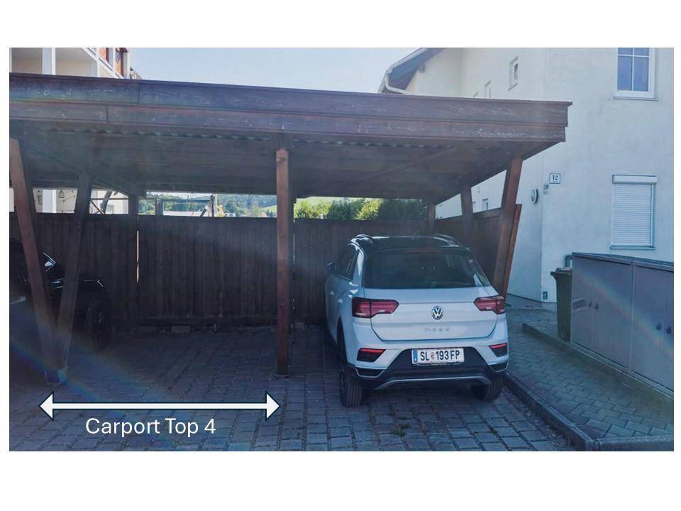 Überdachter Carport-Stellplatz für ein Fahrzeug mit gepflastertem Zugangsbereich.