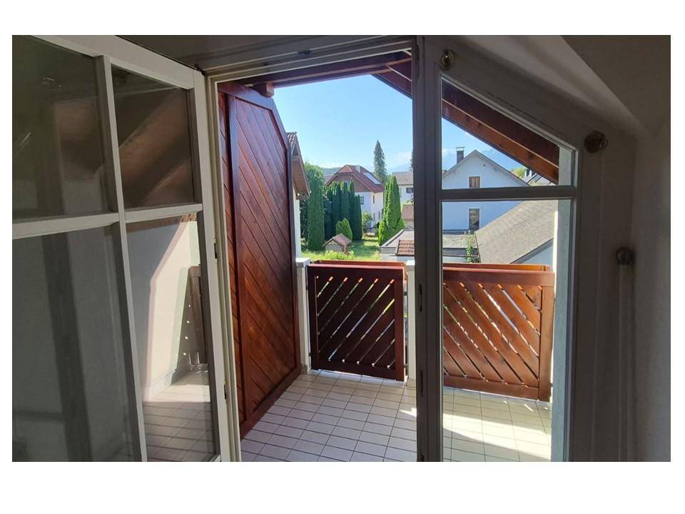 Sonniger Balkon mit Holzelementen und weitem Blick über die umliegende Wohngegend.
