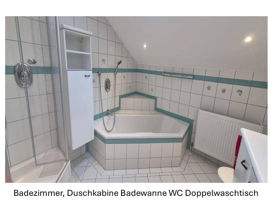 Badezimmer mit Eckbadewanne, Duschkabine und weißen Fliesen mit blauer Bordüre.