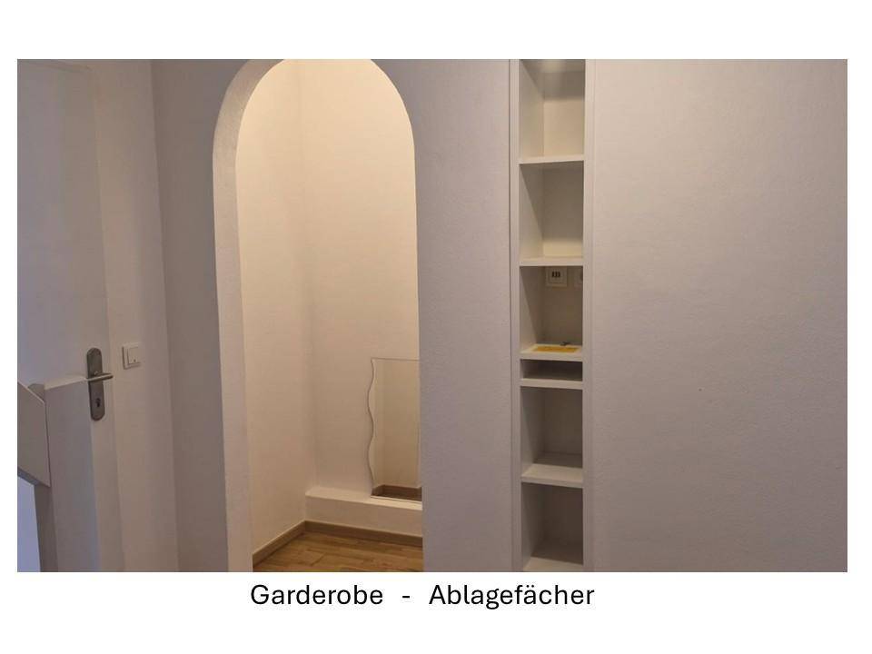 Heller Flurbereich mit integrierten Ablagefächern und einem dekorativen Rundbogen.