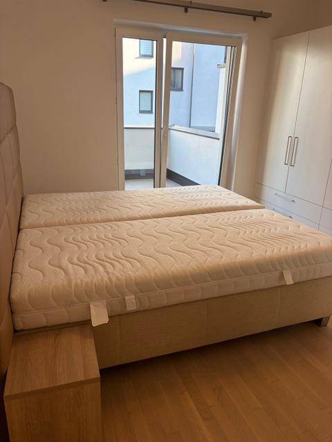 Schlafzimmer mit Doppelbett, großem Kleiderschrank und Zugang zum Balkon.