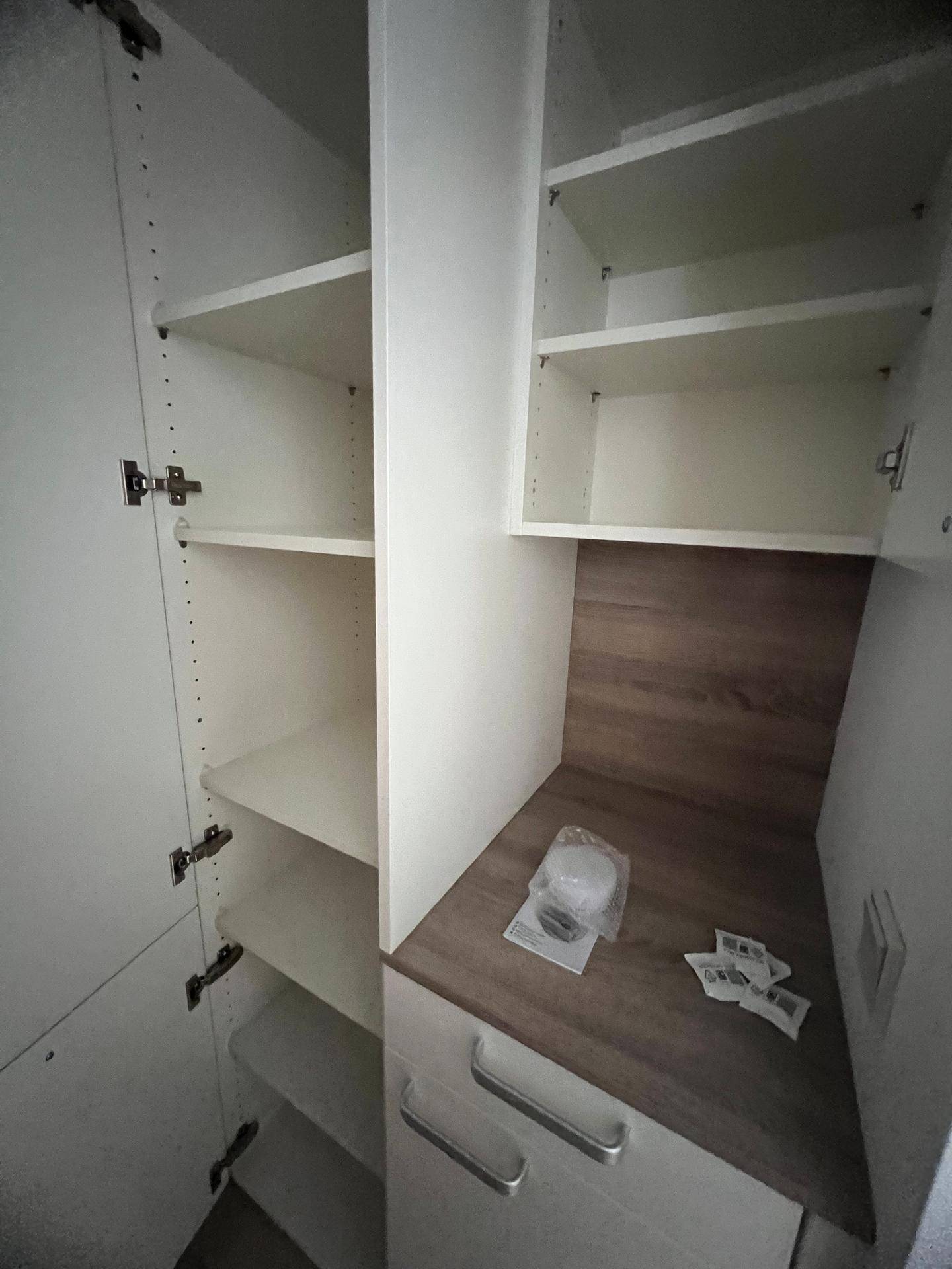 Innenansicht eines weißen Schranks mit Regalböden, ideal für Stauraum.